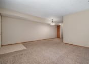 Thumbnail 23 of 27 - a living room and dining room with carpeted floors. Omaha, NE Woodland Pines Apartments