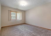 Thumbnail 20 of 27 - Omaha, NE Woodland Pines Apartments. A bedroom with a window and a carpeted floor