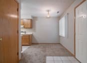 Thumbnail 19 of 27 - Omaha, NE Woodland Pines Apartments. A kitchen and living room with a white door