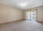 Thumbnail 18 of 27 - Omaha, NE Woodland Pines Apartments. A living room with a sliding glass door