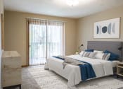 Thumbnail 7 of 27 - a bedroom with a bed and a sliding glass door  at Woodland Pines, Omaha, Nebraska