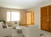 Thumbnail 4 of 27 - a living room with white furniture and a large window  at Woodland Pines, Omaha, NE