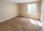 Thumbnail 21 of 34 - an empty room with carpet and a window. Omaha, NE Evergreen Terrace Apartments
