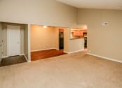 Thumbnail 15 of 34 - an empty living room and kitchen with wood flooring. Omaha, NE Evergreen Terrace Apartments