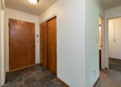Thumbnail 14 of 34 - the hallway of a home with two doors and a tile floor. Fargo, ND Islander Apartments
