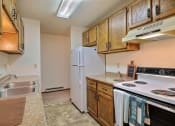 Thumbnail 16 of 18 - a kitchen with white appliances and wooden cabinets. Fargo, ND Pacific South Apartments.