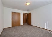 Thumbnail 9 of 25 - Empty living room with carpet and two doors to a closet  at Park Place Apartments in Fargo, ND