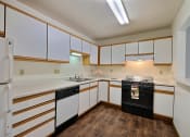 Thumbnail 8 of 25 - Kitchen with white cabinets and black appliances at Park Place Apartments in Fargo, ND, 58103