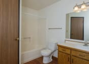 Thumbnail 19 of 20 - a bathroom with a toilet and a sink and a shower. Fargo, ND Park Circle Apartments.