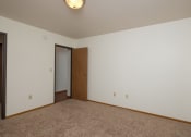 Thumbnail 17 of 20 - a bedroom with carpet and a door to a closet. Fargo, ND Park Circle Apartments.