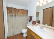 Thumbnail 13 of 20 - a bathroom with a sink and a toilet and a shower. Fargo, ND Park Circle Apartments.