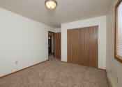 Thumbnail 11 of 20 - A bedroom with carpet and a closet. Fargo, ND Park Circle Apartments.