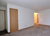 Thumbnail 9 of 23 - A living room of an empty apartment with a door to the hallway at Parkwest Gardens, 58078