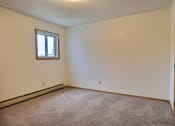 Thumbnail 11 of 23 - Bedroom with carpeted floors and a window at Parkwest Gardens West Fargo
