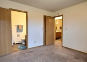 Thumbnail 12 of 23 - Bedroom with a bathroom attached and a closet at Parkwest Gardens West Fargo