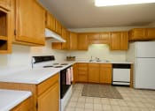 Thumbnail 8 of 15 - A kitchen with white appliances. Pinehurst Apartments