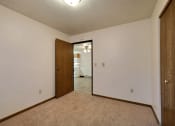 Thumbnail 9 of 21 - a bedroom with a door to a kitchen.Fargo, ND Prairiewood Courts Apartments
