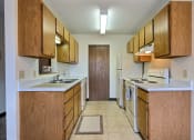 Thumbnail 6 of 26 - a kitchen with white appliances and wooden cabinets. Fargo, ND Prairiewood Meadows