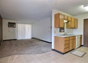 Thumbnail 5 of 26 - A living room with a glass sliding door with a kitchen. Fargo, ND Prairiewood Meadows