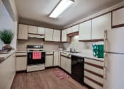 Thumbnail 8 of 25 - Grand Forks Primrose Apartments. A  kitchen with white cabinets and black and white appliances