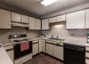 Thumbnail 9 of 25 - Grand Forks Primrose Apartments. A kitchen with white and black appliances