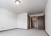 Thumbnail 21 of 25 - Grand Forks Primrose Apartments. A bedroom with white walls and carpet