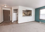 Thumbnail 17 of 25 - Grand Forks Primrose Apartments. An empty living room with a kitchen in the background