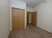 Thumbnail 6 of 23 - a bedroom with two doors and a hallway to a closet. Fargo, ND North Sky Apartments
