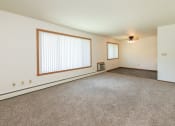 Thumbnail 6 of 34 - an empty living room with carpet and a large window. Fargo, ND Islander Apartments