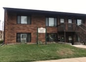 Thumbnail 9 of 10 - a brick building with a sign in front of it. Bismarck, ND Riverpark Apartments