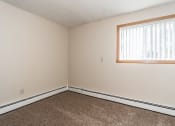 Thumbnail 14 of 23 - Grand Forks, ND Riverwood Apartments. A bedroom with carpet and a window