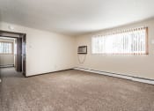 Thumbnail 10 of 23 - Grand Forks, ND Riverwood Apartments. A living room with carpet and a window