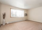 Thumbnail 11 of 23 - Grand Forks, ND Riverwood Apartments. A living room with a large window and carpeting