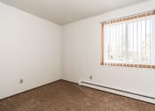 Thumbnail 19 of 23 - Grand Forks, ND Riverwood Apartments. A bedroom with carpet and a window