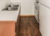 Thumbnail 18 of 23 - Grand Forks, ND Riverwood Apartments. A kitchen with a sink and a refrigerator