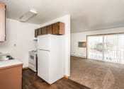 Thumbnail 17 of 23 - Grand Forks, ND Riverwood Apartments. A kitchen with a white refrigerator and stove and a window