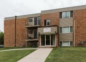 Thumbnail 23 of 23 - Grand Forks, ND Riverwood Apartments. A brick apartment building with a sidewalk and a bike parked in front