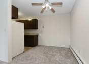 Thumbnail 10 of 41 - an empty living room with a ceiling fan and a kitchen. Roseville, MN Rosedale Estates