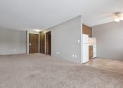 Thumbnail 26 of 41 - an empty living room with a kitchen and a ceiling fan. Roseville, MN Rosedale Estates