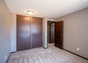 Thumbnail 34 of 41 - a bedroom with a closet and a door to a hallway. Roseville, MN Rosedale Estates Apartments