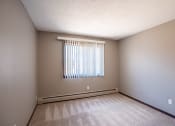 Thumbnail 33 of 41 - an empty room with a window and a carpeted floor. Roseville, MN Rosedale Estates Apartments