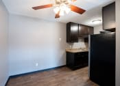 Thumbnail 28 of 41 - an empty kitchen with a ceiling fan and dark cabinets. Roseville, MN Rosedale Estates Apartments