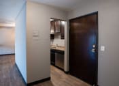 Thumbnail 35 of 41 - an open door leading into a kitchen with a sink and a refrigerator. Roseville, MN Rosedale Estates Apartments