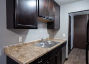 Thumbnail 29 of 41 - a kitchen with dark wood cabinets. Roseville, MN Rosedale Estates Apartments