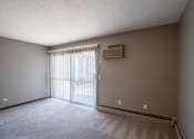 Thumbnail 27 of 41 - an empty living room with a sliding glass door to a balcony. Roseville, MN Rosedale Estates Apartments