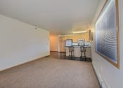Thumbnail 5 of 18 - a living room with a kitchen in the background. Moorhead, MN Sandy Creek Apartments