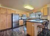 Thumbnail 11 of 18 - a kitchen with stainless steel appliances and wooden cabinets. Moorhead, MN Sandy Creek Apartments