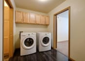 Thumbnail 9 of 18 - a laundry room with a washing machine and a dryer in it. Moorhead, MN Sandy Creek Apartments
