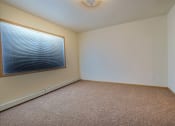 Thumbnail 13 of 18 - a bedroom with a window and carpet. Moorhead, MN Sandy Creek Apartments