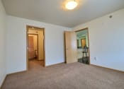 Thumbnail 14 of 18 - a bedroom with carpet and a door to a bathroom. Moorhead, MN Sandy Creek Apartments